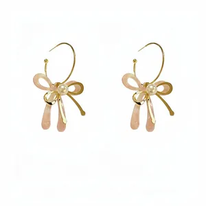 Eleganti orecchini a cerchio a C con fiocco in acetato rosa e perla centrale.