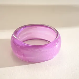 Macro detail of a purple resin bangle showing fine shimmering glitter and smooth texture