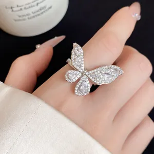 Dettaglio di un anello a farfalla aperto in argento con zirconi cubici scintillanti.