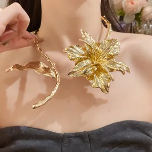 Close-up macro detail of the textured gold leaf and flower choker necklace on model
