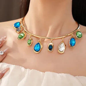 Close-up of luxury gold-tone choker featuring vibrant teardrop and oval crystal charms