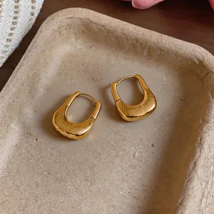 Close-up view of elegant 18K gold plated U-shaped earrings with a unique wrinkled texture