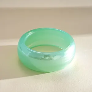 Macro view showing the translucent texture and stripes of the green resin chunky bracelet