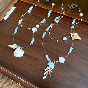 Detailed view of ocean-themed necklaces with pearls, sea glass, and shell pendants
