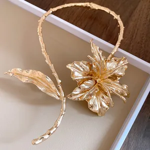 Close-up of gold metallic flower and leaf choker with a unique crinkled texture.