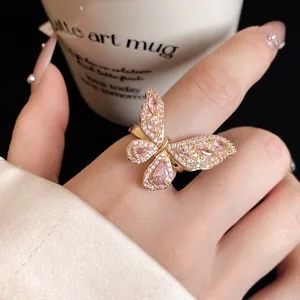 Primo piano di anello a farfalla dorato con pavé di zirconi rosa brillanti e fini