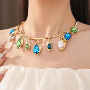 Detailed macro view of gold choker necklace featuring colorful teardrop rhinestones on model neck.