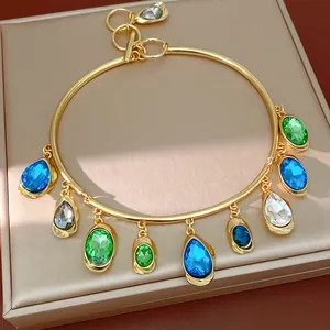 Close-up of gold-tone choker with vibrant teardrop and oval crystal charms
