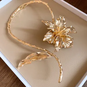 Macro detail of elegant golden metal flower and leaf choker in luxury display tray