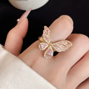 Primo piano dettagliato di un anello a farfalla rosa con micro zirconi incastonati.