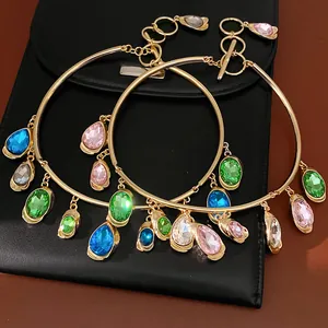 Close-up detail of gold-tone choker necklaces with colorful oval and teardrop gems