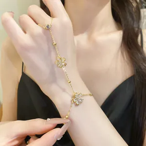 Elegant 14k gold plated zircon flower hand chain with integrated ring shown on model