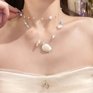 Close-up detail of double-layered ocean style necklace with shell and pearl charms