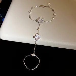 Detailed close-up of a silver-tone slave bracelet with sparkling zircon flower charms.