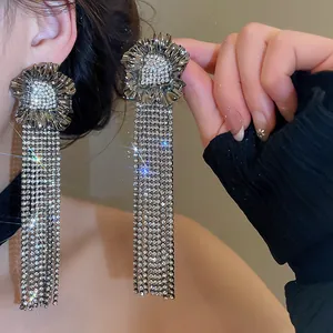 Close-up of exquisite gunmetal rhinestone tassel fringe earrings with flower design.