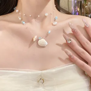 Detailed close-up of a blue ocean style double-layered necklace with shells and pearls.