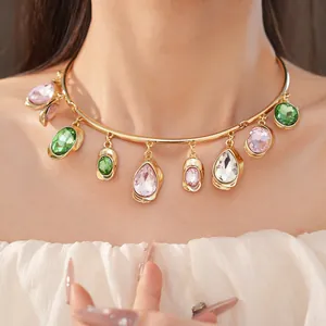 Macro view of a luxury gold choker necklace with vibrant waterdrop and oval rhinestones