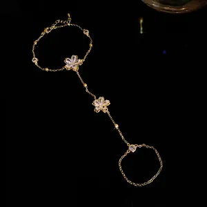 Exquisite close-up of a 14k gold-plated zircon flower slave bracelet and hand chain ring.