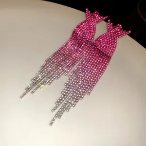 Macro detail of elegant pink gradient rhinestone tassel earrings with a sparkling finish
