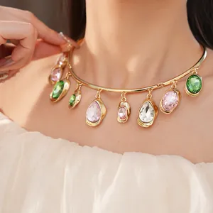 Detail shot of a gold statement choker necklace with teardrop and oval crystals.