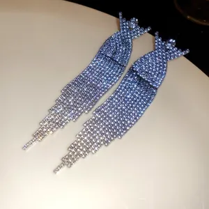 Close-up of sparkling long tassel earrings with heavy rhinestone embellishment