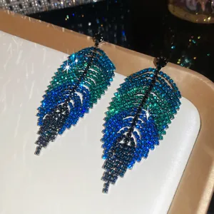 Detailed macro view of leaf-shaped earrings with blue to green ombre rhinestone clusters