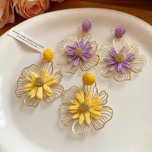 Elegant raffia flower earrings with metal frame and silver needle for stylish women.
