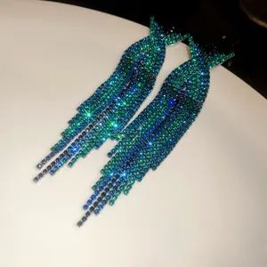 Close-up of sparkling blue and green rhinestone long tassel earrings with silver needles