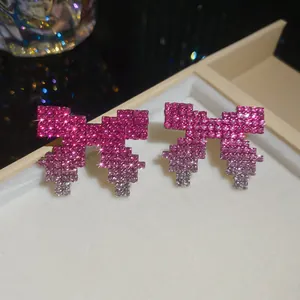 Exquisite pink pixel bow stud earrings with sparkling gradient rhinestone finish.
