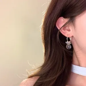 Detailed view of sweet dopamine-style transparent ball hoop earrings on a model