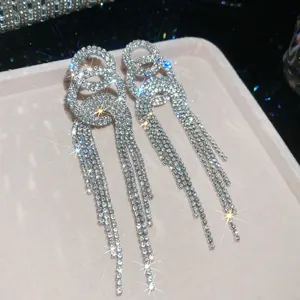 Detailed close-up view of sparkling rhinestone tassel fringe drop earrings in silver tone