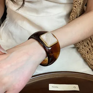 Vista detallada de un brazalete retro de acrílico carey con inserto cuadrado jaspeado.
