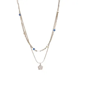 Double-layered silver necklace featuring a sparkling zircon star pendant and blue beads