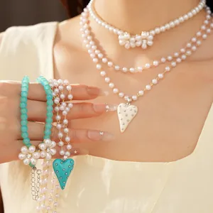 Vue détaillée de colliers de perles élégants à plusieurs rangs avec fleurs et cœurs