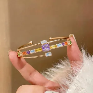 Detail shot of luxury 18k gold plated open cuff bangle with colorful square zircons