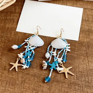 Boucles d'oreilles en perles avec coquillages blancs et breloques étoiles de mer.