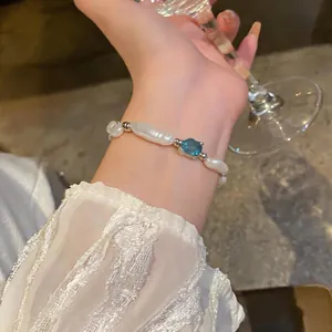 Close-up of irregular pearl bracelet with elegant blue gemstone in French style