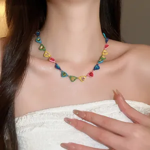 Collar de corazones con diamantes de imitación de colores en el cuello de una modelo.
