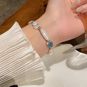 Close-up of irregular baroque pearl bracelet with a teardrop blue crystal detail
