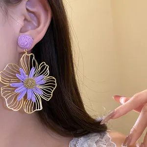 Detailed close-up of a stylish large purple raffia flower earring worn on an ear