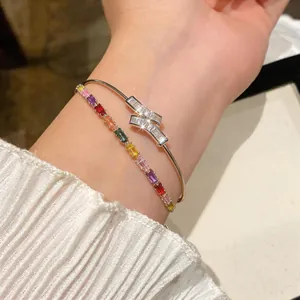 Close-up of 18k gold plated bangle with sparkling cubic zirconia and rainbow bracelet