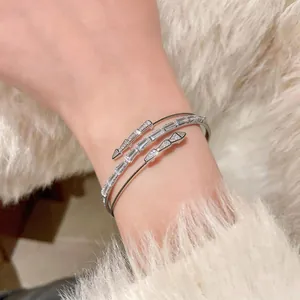 Close-up of elegant 18k gold plated open bangle with square cubic zirconia stones on wrist