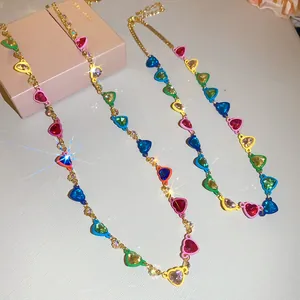 Primer plano de collares de cristal de corazones coloridos con cadenas doradas