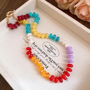 Detailed view of a vibrant rainbow acrylic beaded necklace in a white display tray.