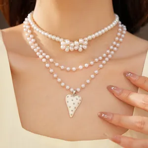 Vue détaillée d'un collier de perles à plusieurs rangs avec pendentif cœur