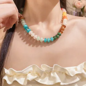 Close-up detail view of a colorful rainbow acrylic beaded necklace on the model's collarbone