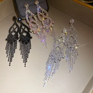 Close-up of luxurious rhinestone tassel earrings in black, silver, and iridescent colors.