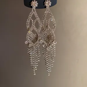 Close-up of elegant silver needle chandelier earrings with rhinestones and tassels