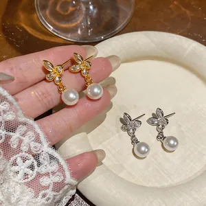 Detailed close-up of 18k gold plated butterfly earrings with zirconia and pearls