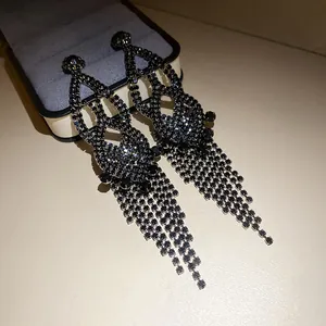 Detailed close-up view of glamorous dark rhinestone tassel earrings with vintage finish